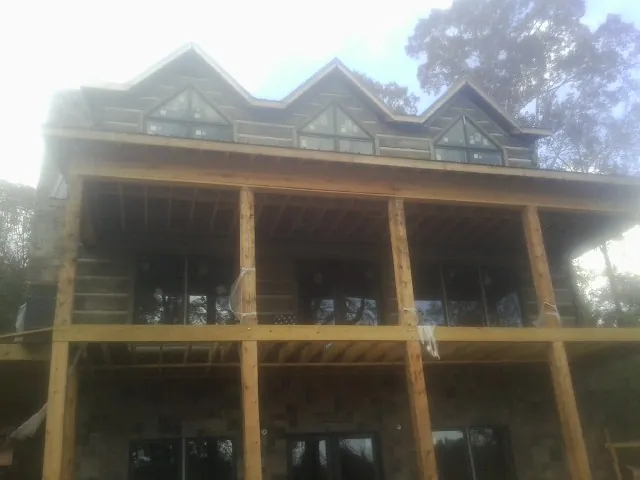 Dormers and porch framing on a large log home under construction — Roof Coating work by our crew in Coraopolis