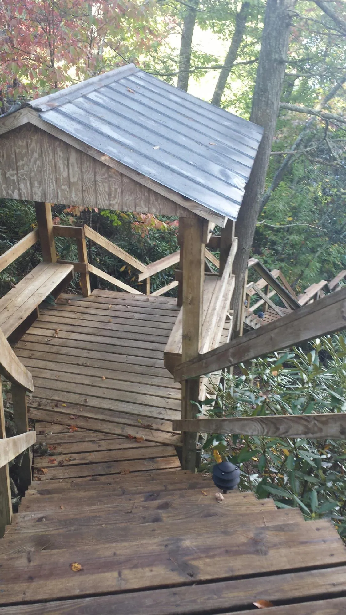 Metal roofed shelter over wooden steps on a wooded walkway — Skylight Repair & Installation work by our crew in Coraopolis