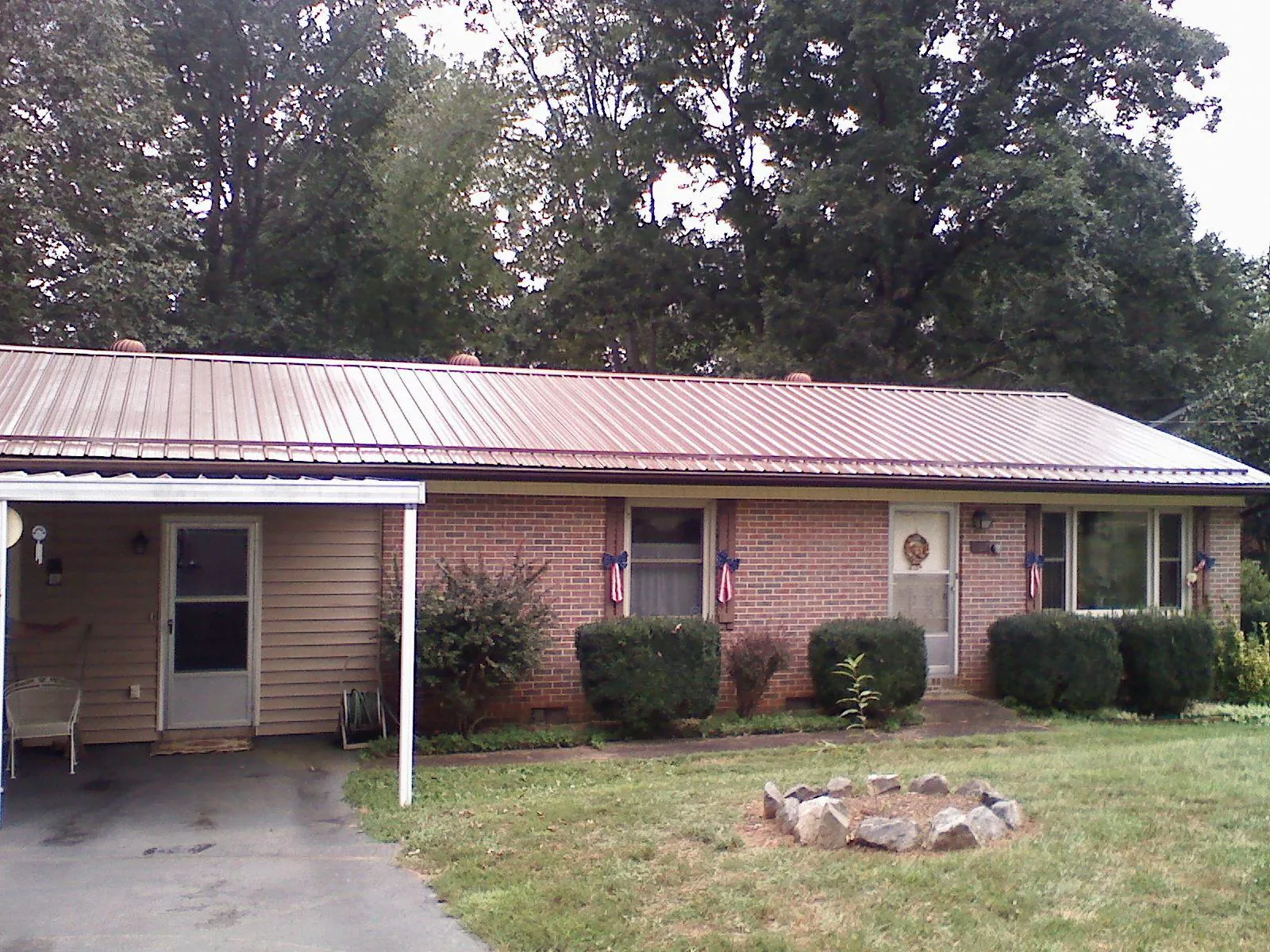 Bronze metal roof and carport on a brick ranch home — Roof Repair work by our crew in Coraopolis